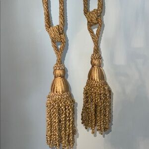 two handcrafted curtain and drapery tassel tieback in a golden beige color